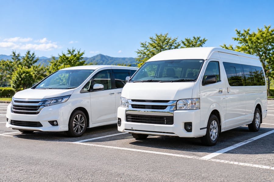 駐車場に並んで停まる、白いミニバンとひと回り大きい白いワンボックスワゴン